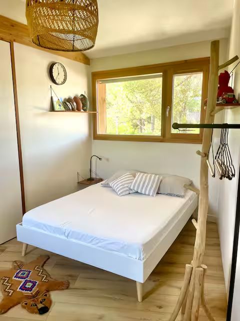 Chambre lumineuse avec fenêtre sur les arbres