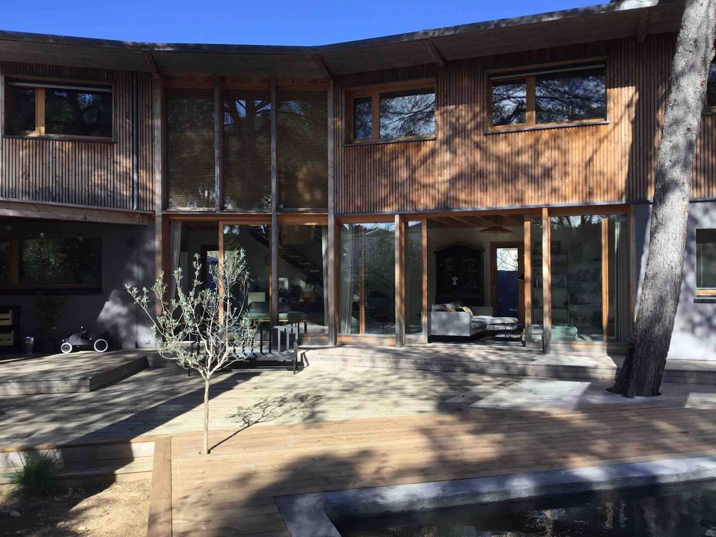 La façade en bois et ses grandes baies vitrées